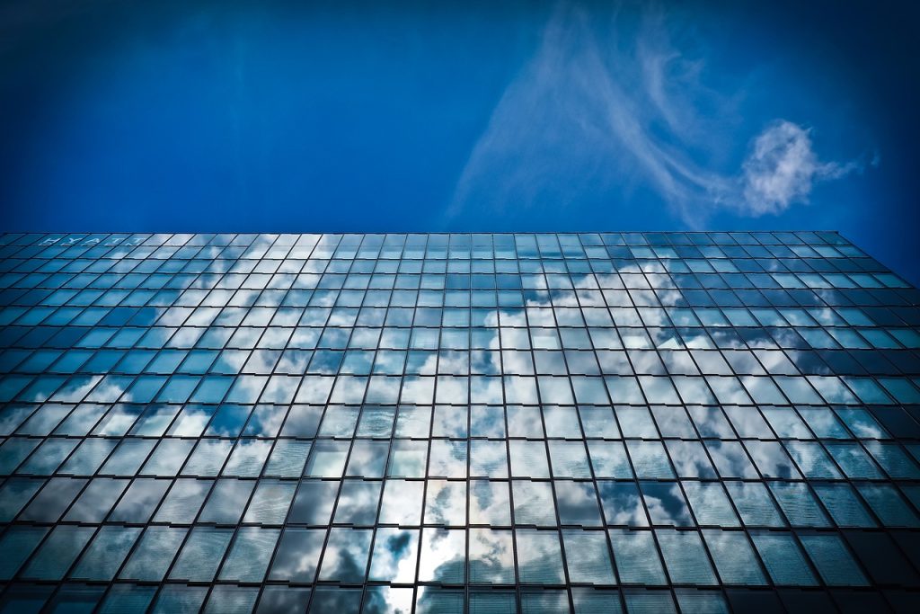 Imagen de unos edificios acristalados en su exterior donde se ve el reflejo del cielo